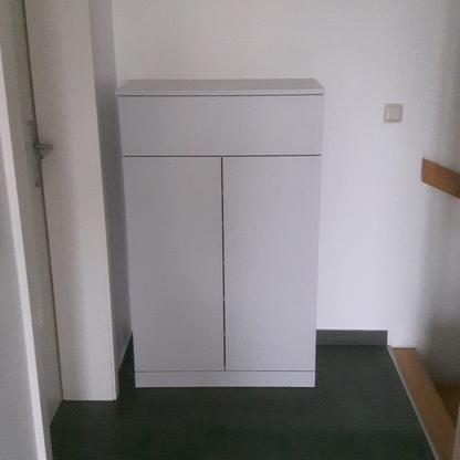 Weißer Schrank im Flur Weißer Einbauschrank mit zwei Türen steht passgenau in einer Flurnische neben einer Treppe.