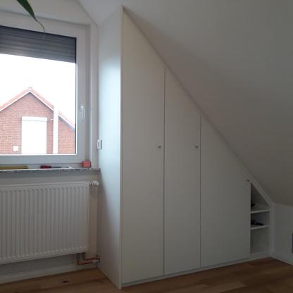 Einbauschrank unter Dachschräge Weißer Einbauschrank nutzt den Platz unter der Dachschräge neben dem Fenster passgenau aus.