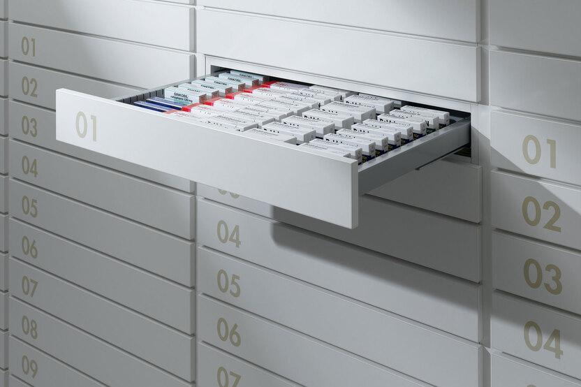 Detailaufnahme von Medikamentenschubläden Detailaufnahme von schmalen weißen Medikamentenschubläden mit dezenter Nummerierung und sichtbarer Medikamentenaufteilungen.