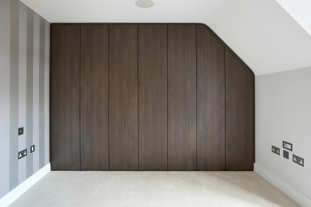 Einbauschrank mit Türen an hohem Drempel Dunkler Einbauschrank mit sieben Türen an hohem Drempel