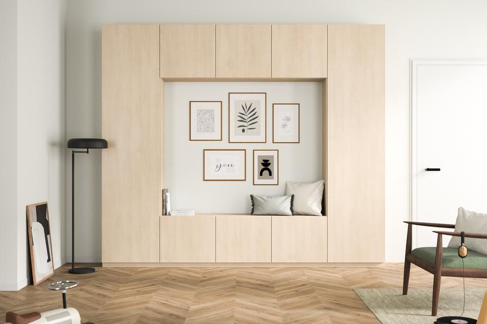 Integrierter Schrank nach Maß mit Sitznische im Wohnzimmer Ein maßgefertigter, heller Holzschrank mit eingebauter Sitznische und dekorativen Rahmen an der Wand, harmonisch in einen gemütlichen Wohnbereich integriert.