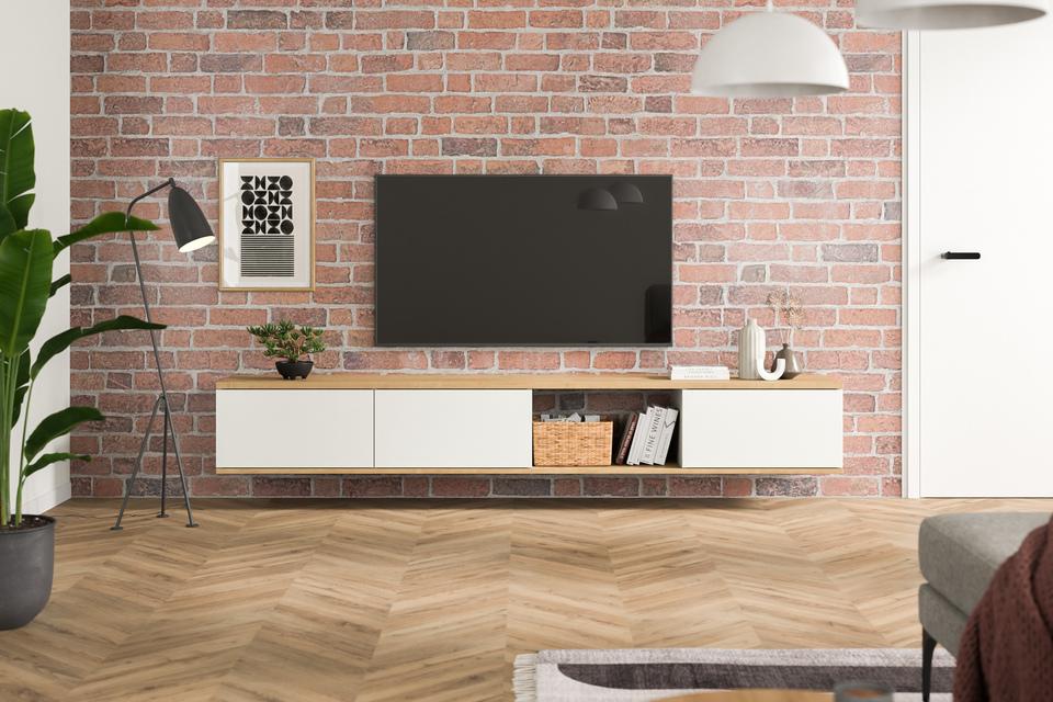Stilvolles Hängeboard nach Maß an einer Backsteinwand Maßangefertigtes Hängeboard in Weiß, minimalistisch gestaltet, unter einem Wandfernseher, vor einer roten Backsteinwand, ergänzt durch Pflanzen und Bücher.