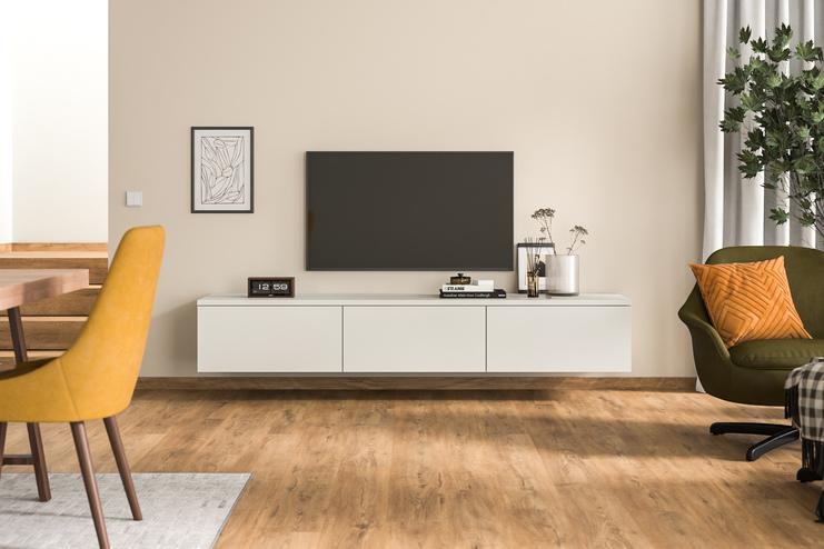 Modernes Hängeboard nach Maß unter Fernseher im stilvollen Wohnzimmer Ein maßangefertigtes, wandmontiertes Hängeboard in schlichtem Weiß unter einem Wandfernseher, ergänzt durch zeitgenössische Deko und Grünpflanzen, fügt sich nahtlos in ein modernes Wohnambiente ein.